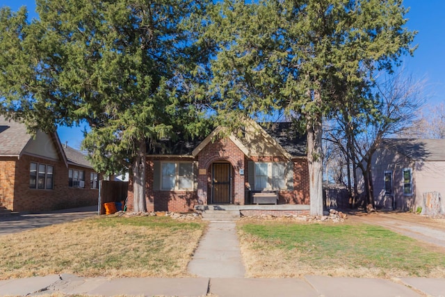 view of front of property featuring a front yard and brick siding