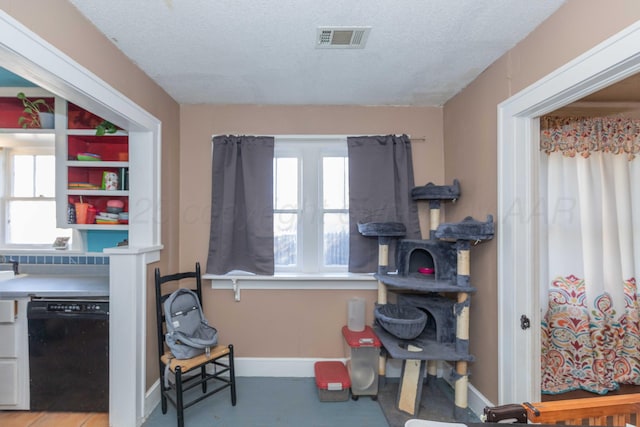 interior space with baseboards, visible vents, and a textured ceiling