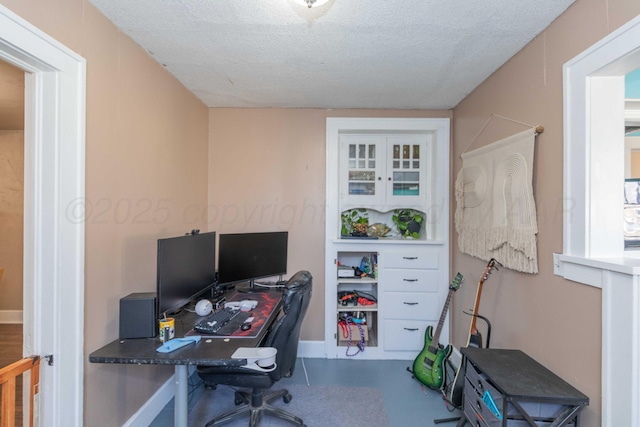 office area with a textured ceiling and baseboards