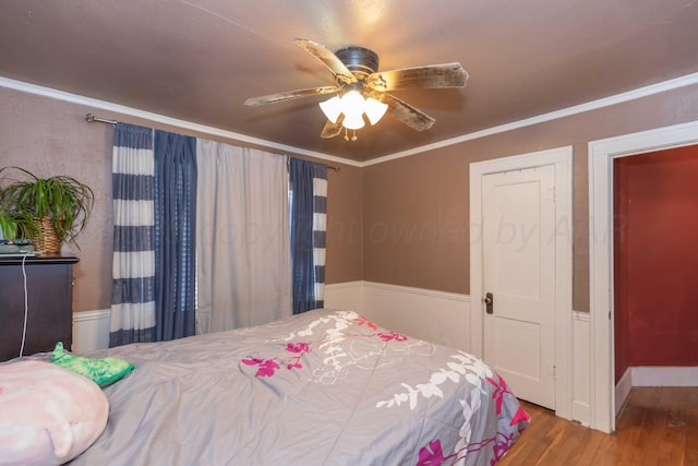 bedroom with ceiling fan, wood finished floors, and crown molding