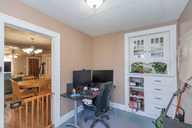 office area with a textured ceiling, a chandelier, and baseboards