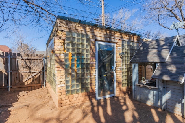 view of outbuilding featuring fence and a gate