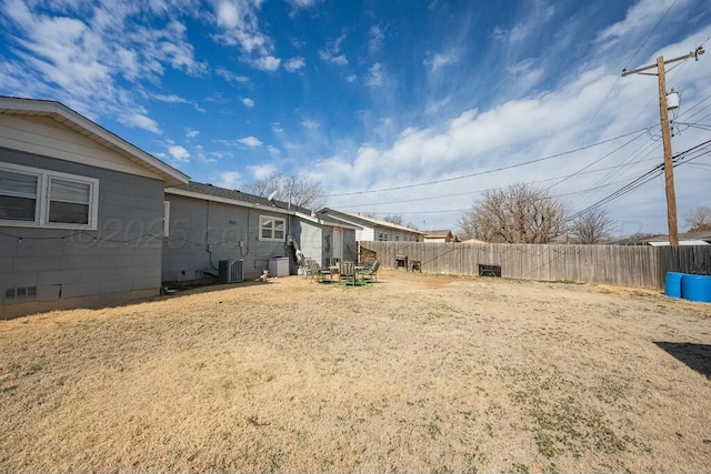 view of yard featuring fence and central AC