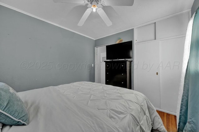 bedroom featuring ornamental molding, ceiling fan, and wood finished floors