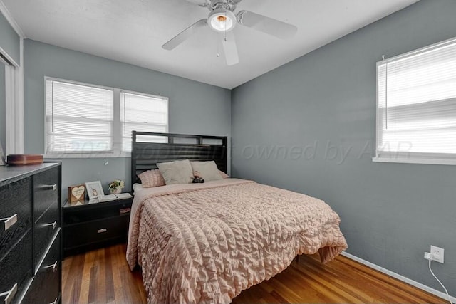 bedroom with ceiling fan, baseboards, and wood finished floors