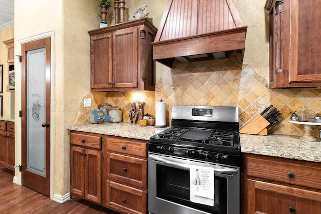 6004 Glenwood Dr, Amarillo, TX 79119 - kitchen featuring stainless steel range with gas cooktop, dark wood-type flooring, backsplash, custom range hood, and a textured wall