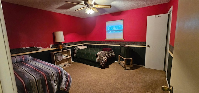 carpeted bedroom featuring a textured ceiling and ceiling fan