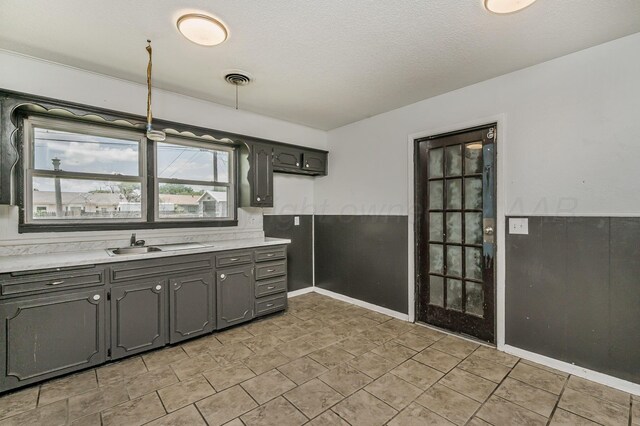 2902 Pryor St, Amarillo, TX 79103 - kitchen featuring light countertops, a textured ceiling, and gray cabinets