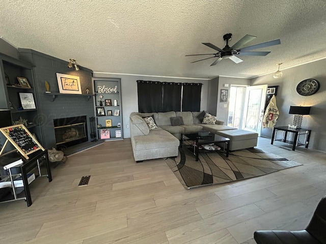 712 Groom Ave, Panhandle, TX 79068 - living area featuring wood finished floors, a textured ceiling, ceiling fan, and a fireplace
