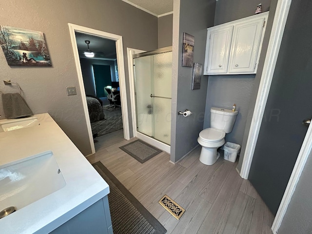 712 Groom Ave, Panhandle, TX 79068 - bathroom with a stall shower, double vanity, wood finished floors, a ceiling fan, and ornamental molding