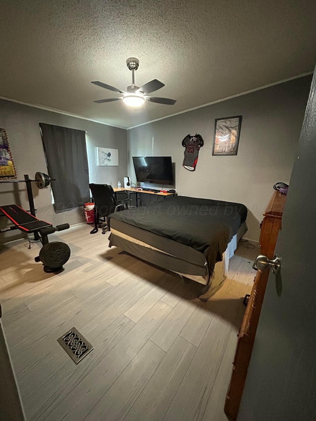 712 Groom Ave, Panhandle, TX 79068 - bedroom with wood finished floors, a textured ceiling, ceiling fan, and ornamental molding