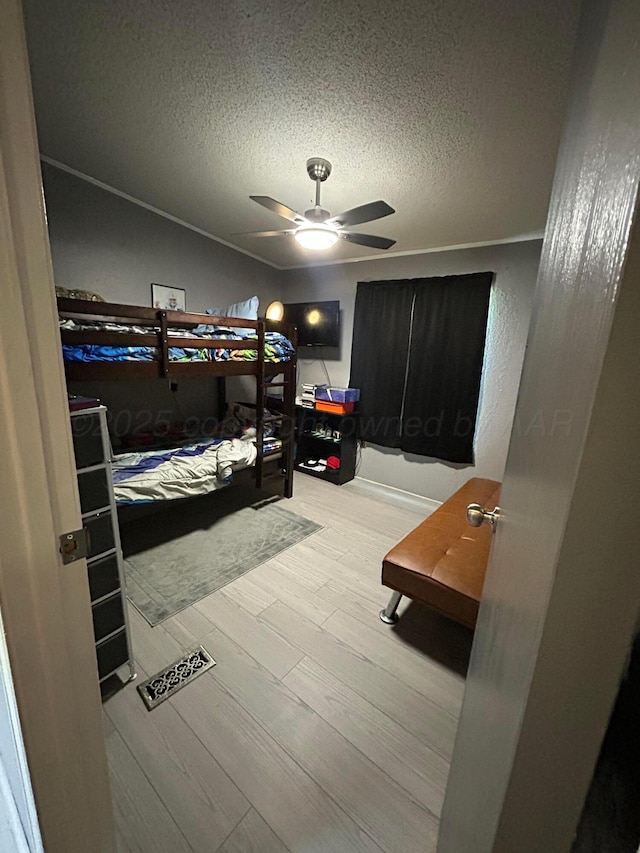712 Groom Ave, Panhandle, TX 79068 - bedroom featuring wood finished floors, a textured ceiling, and a ceiling fan