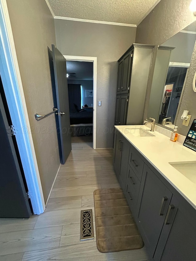 712 Groom Ave, Panhandle, TX 79068 - ensuite bathroom featuring a textured wall, a textured ceiling, double vanity, ornamental molding, and wood finished floors