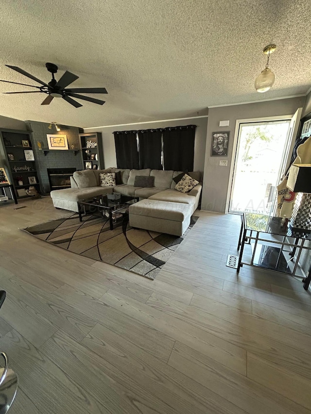 712 Groom Ave, Panhandle, TX 79068 - living area featuring a ceiling fan, wood finished floors, a textured ceiling, and a fireplace