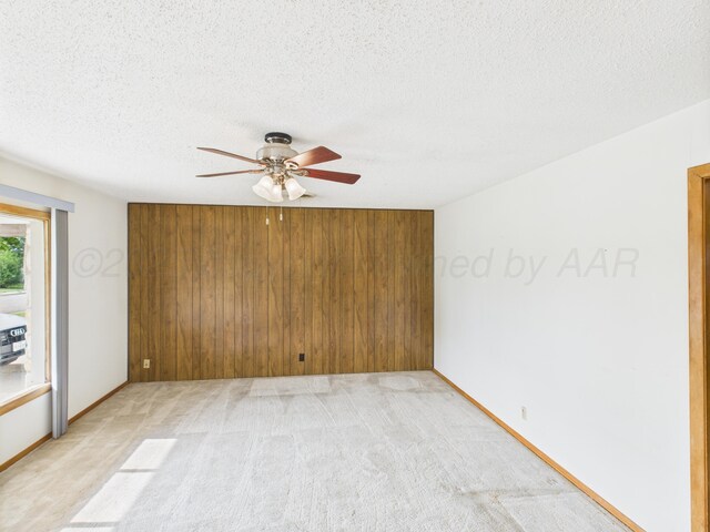 502 Spruce Ave, Dumas, TX 79029 - empty room with ceiling fan, a textured ceiling, light carpet, and baseboards
