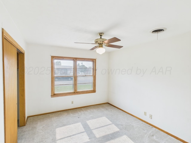 502 Spruce Ave, Dumas, TX 79029 - unfurnished bedroom with baseboards, light carpet, a closet, and a ceiling fan