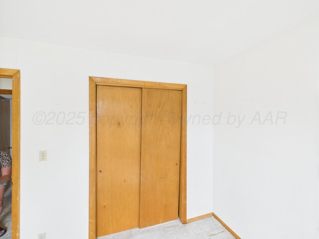 502 Spruce Ave, Dumas, TX 79029 - unfurnished bedroom featuring baseboards, light colored carpet, and a closet