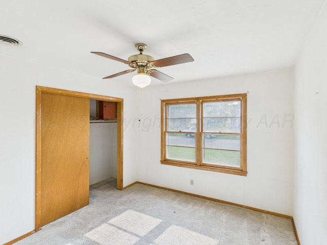 502 Spruce Ave, Dumas, TX 79029 - unfurnished bedroom with light colored carpet, a closet, baseboards, and a ceiling fan