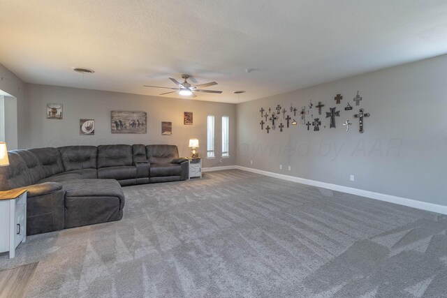 carpeted living room featuring a textured ceiling and ceiling fan