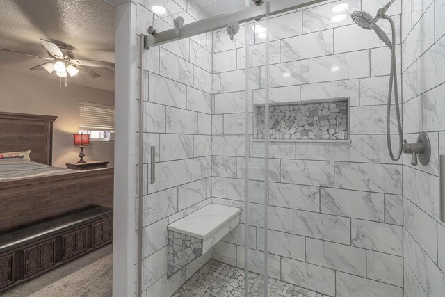 bathroom with ceiling fan, a textured ceiling, and a shower with shower door