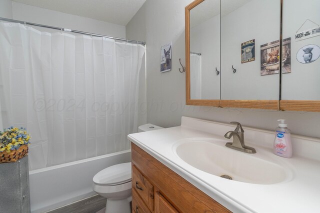 full bathroom featuring toilet, hardwood / wood-style floors, a textured ceiling, vanity, and shower / bathtub combination with curtain