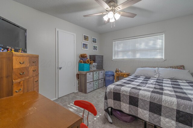 carpeted bedroom featuring a textured ceiling and ceiling fan