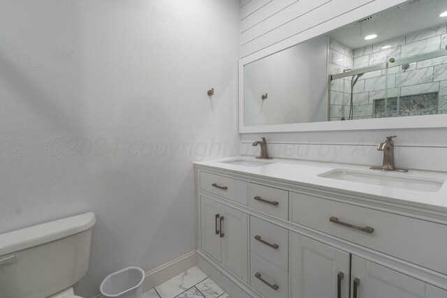 bathroom with toilet, vanity, and a shower with shower door