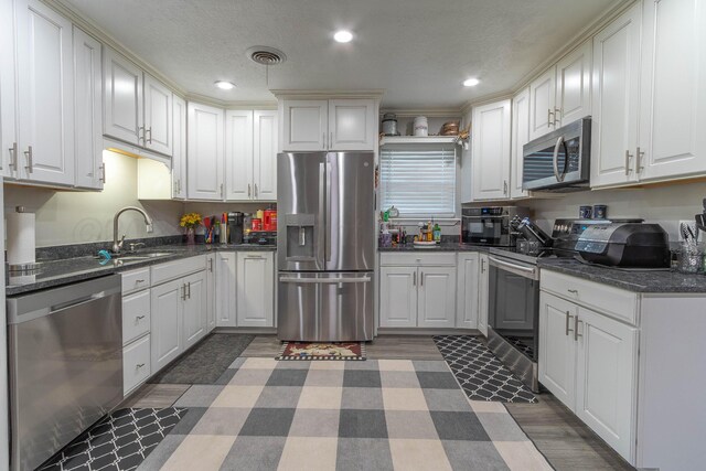 kitchen with white cabinetry, appliances with stainless steel finishes, and sink