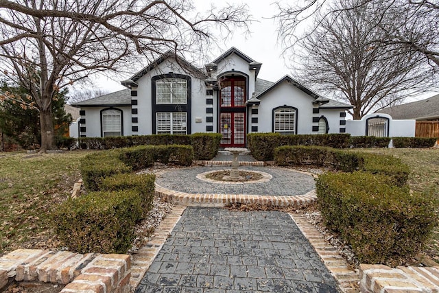 french country style house with french doors and stucco siding