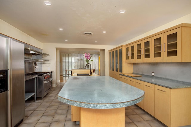 1510 Crockett St, Amarillo, TX 79102 - kitchen with premium appliances, light brown cabinets, light tile patterned floors, a center island with sink, and recessed lighting