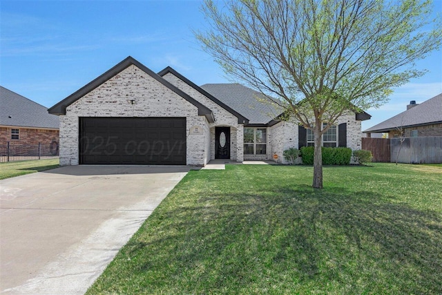 view of front of home with a front lawn, concrete driveway, fence, and a garage