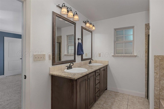 full bathroom with a sink, double vanity, and baseboards