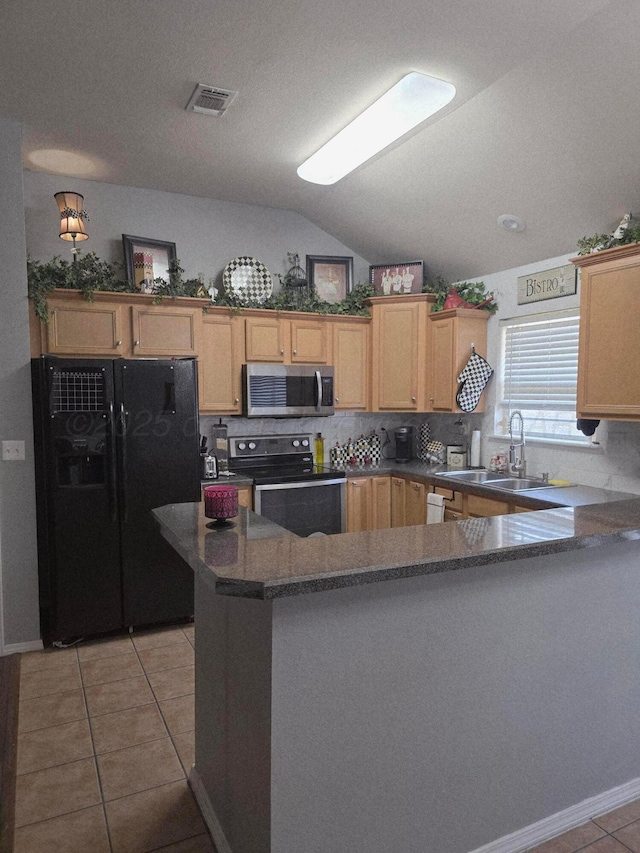 4808 Mammoth Ln, Amarillo, TX 79110 - kitchen featuring black appliances, light tile patterned floors, backsplash, a peninsula, and vaulted ceiling