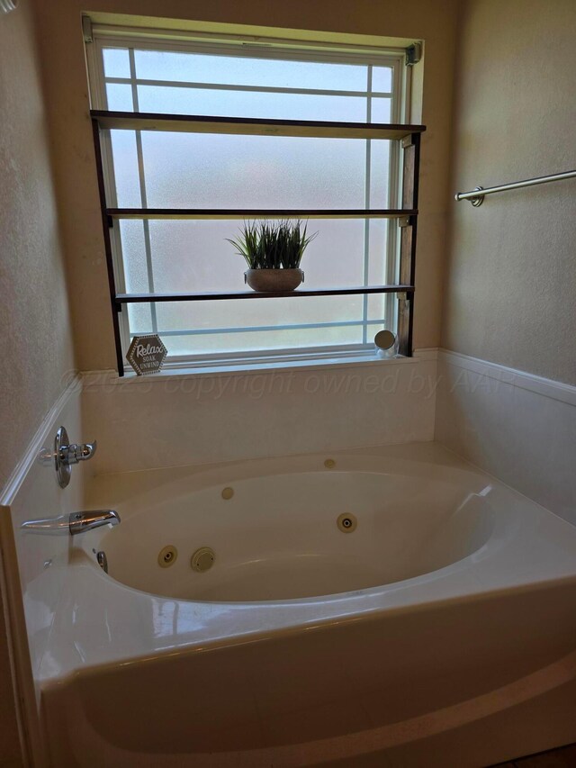4808 Mammoth Ln, Amarillo, TX 79110 - full bathroom featuring a textured wall, a tub with jets, and plenty of natural light