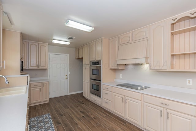 5519 Alvarado Rd, Amarillo, TX 79106 - kitchen with black electric cooktop, custom exhaust hood, double oven, light countertops, and dark wood finished floors