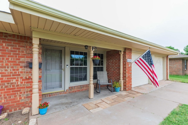 5519 Alvarado Rd, Amarillo, TX 79106 - view of exterior entry with brick siding, driveway, an attached garage, and covered porch