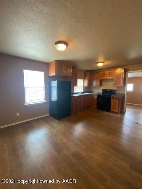 303 S Louisiana St, Amarillo, TX 79106 - kitchen with freestanding refrigerator, range, dark wood finished floors, dark countertops, and healthy amount of natural light