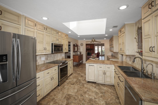 3449 Irving Ln, Amarillo, TX 79121 - kitchen with appliances with stainless steel finishes, decorative backsplash, cream cabinets, ceiling fan, and recessed lighting