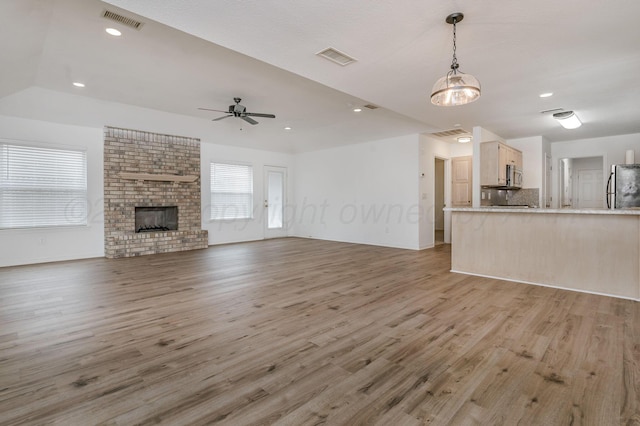 6011 Belpree Rd, Amarillo, TX 79106 - unfurnished living room with ceiling fan, light wood-style flooring, a brick fireplace, and recessed lighting