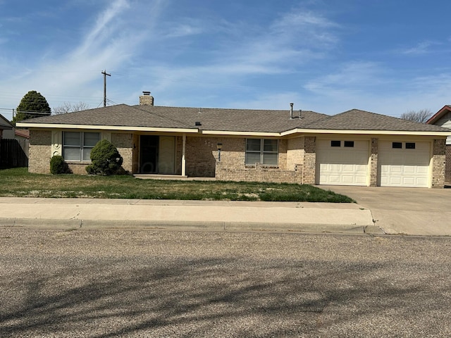 view of front of property with driveway, a chimney, a garage, and brick siding