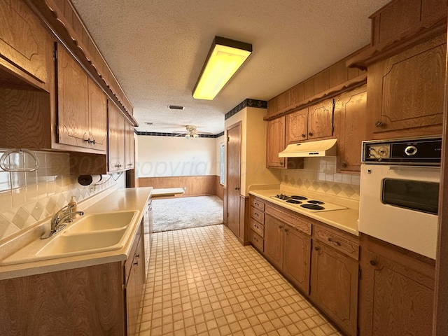 living area with lofted ceiling with beams, carpet, a textured ceiling, wooden walls, and a ceiling fan
