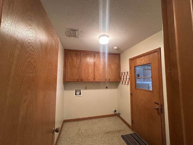 clothes washing area with hookup for a washing machine, baseboards, a textured ceiling, visible vents, and cabinet space
