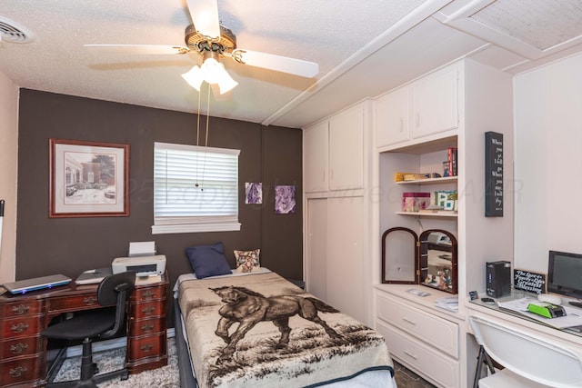 bedroom featuring a ceiling fan, a textured ceiling, and visible vents
