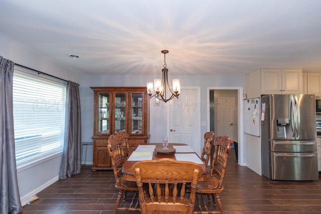 dining space featuring baseboards, a chandelier, and dark wood-style floors