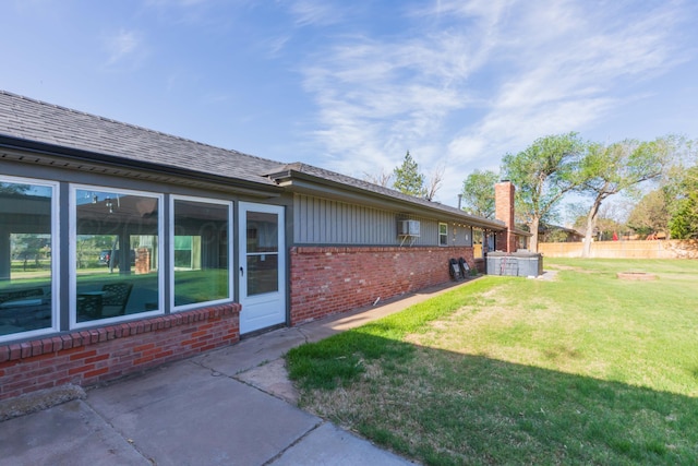 view of home's exterior with a lawn, brick siding, fence, and a chimney