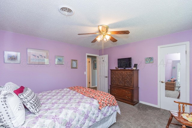 carpeted bedroom featuring ceiling fan, a textured ceiling, and visible vents