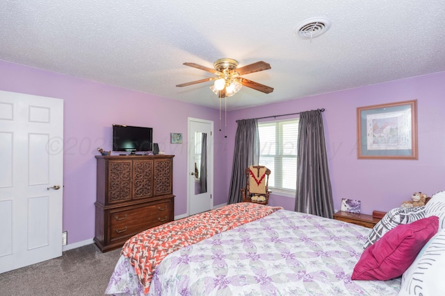 carpeted bedroom with a textured ceiling, visible vents, and a ceiling fan