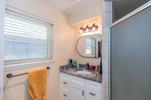 full bathroom with plenty of natural light, vanity, and a shower with door