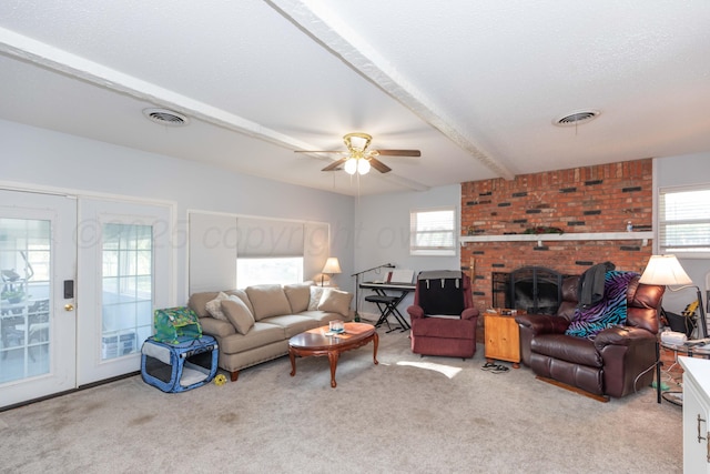 carpeted living area with a brick fireplace, visible vents, ceiling fan, and french doors