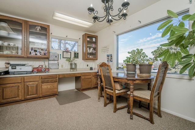 dining area featuring built in desk, an inviting chandelier, and baseboards